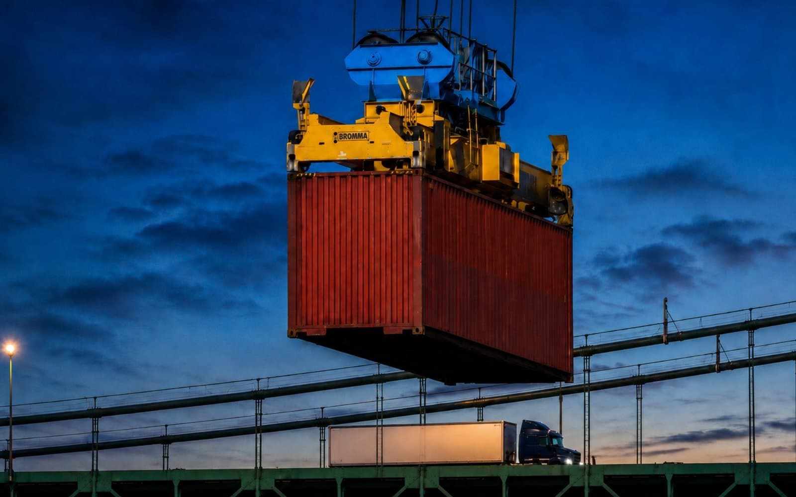 Shipping container being lifted by port crane at dusk