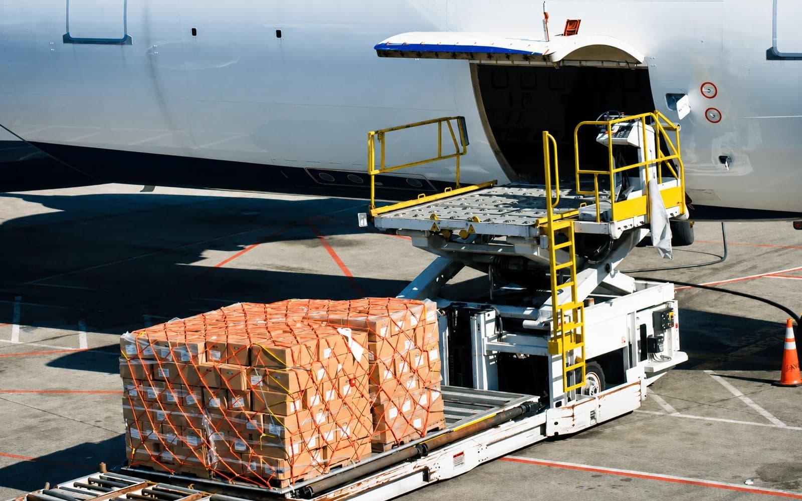 Cargo aircraft being loaded on the tarmac at dusk