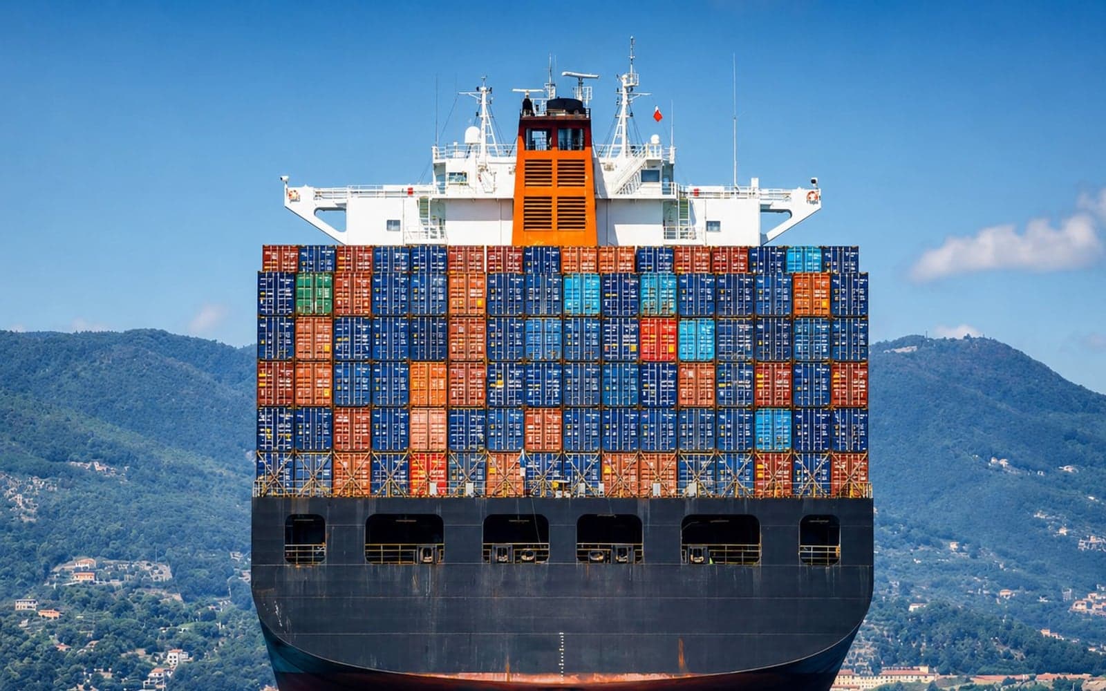 Container ship approaching a coastal port at sunset